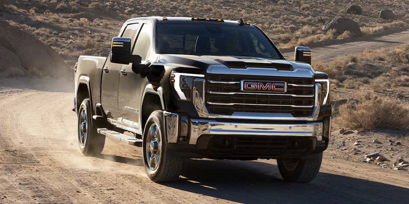 2025 GMC Sierra HD driving on a desert road