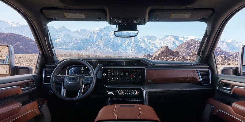 Wide view of the 2025 GMC Sierra HD front dashboard and front window from the rear passenger point of view